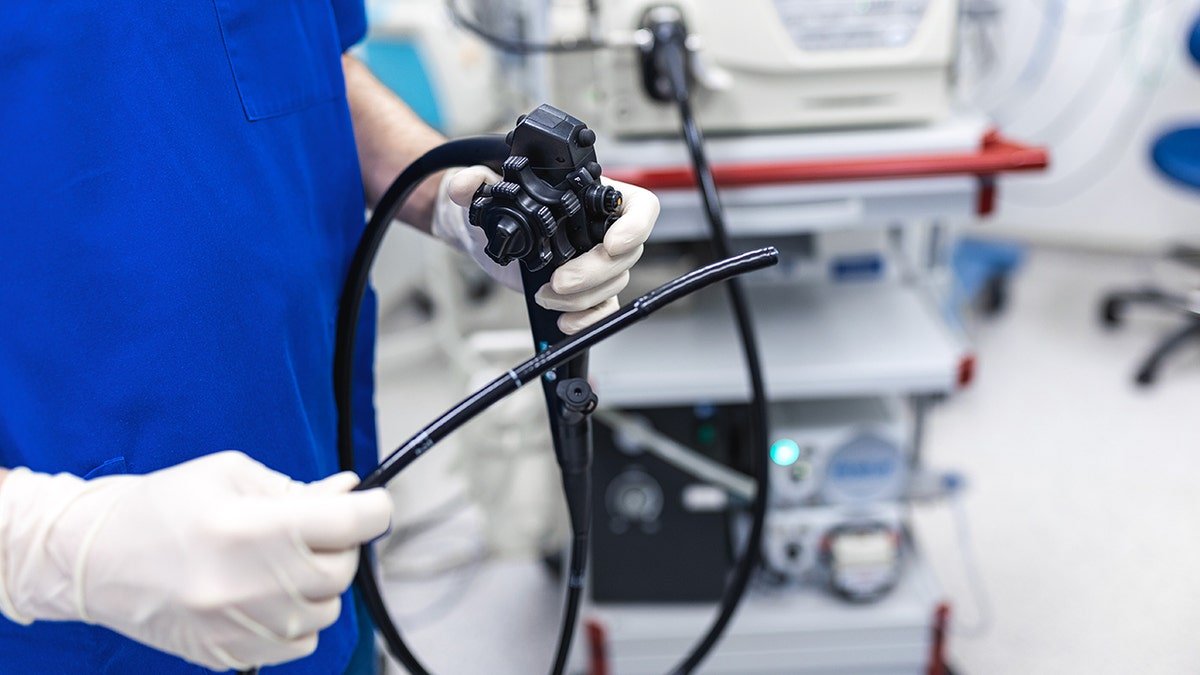 Doctor holding endoscope during colonoscopy. 