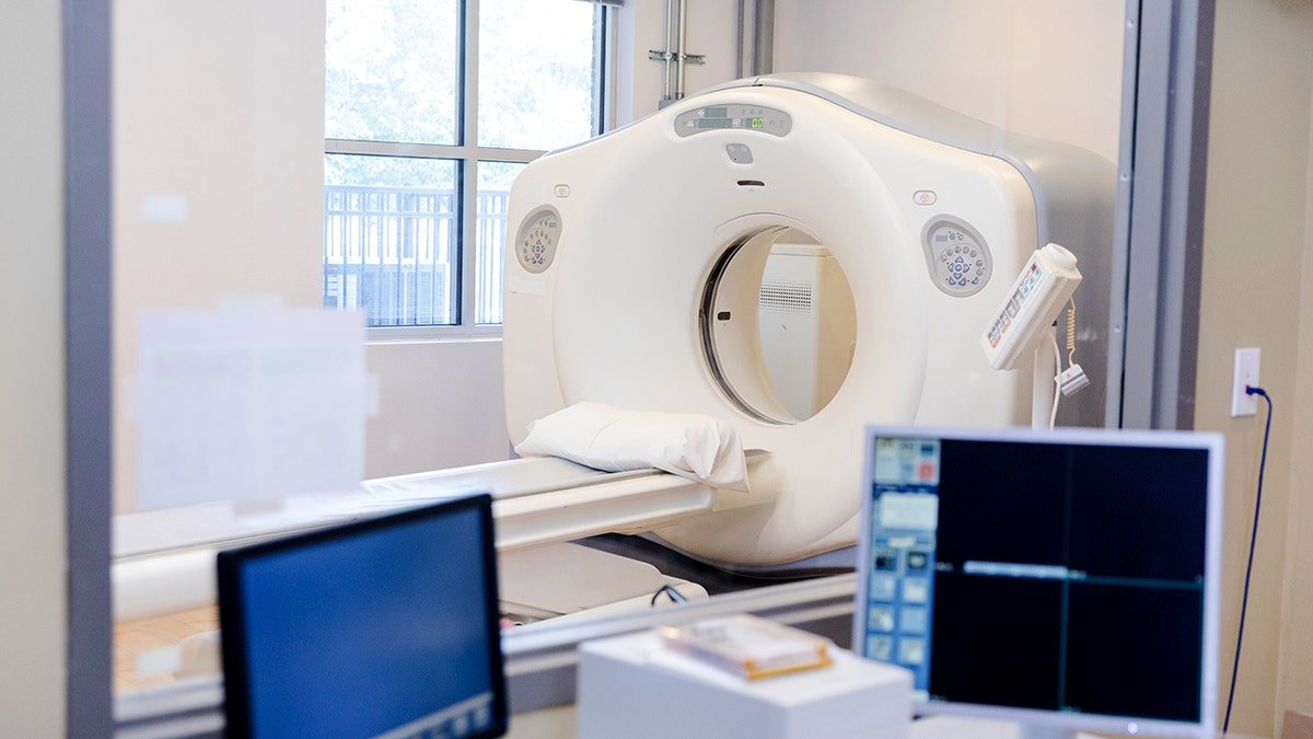 Two computer monitors are seen inside a CT scan control room