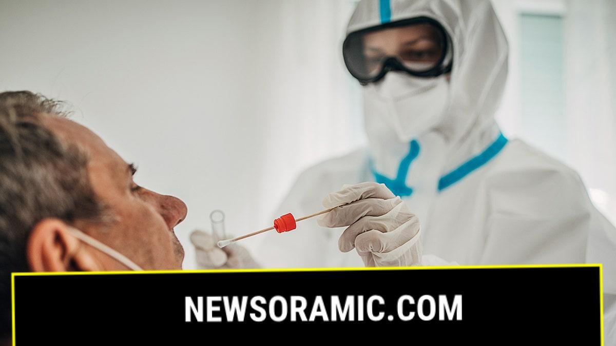 doctor in protective gear swabs infected patient