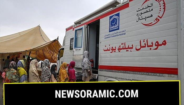 Flood-affected people stand in a queue outside a mobile health unit at a makeshift camp in Chung, in Punjab province, on August 31, 2025. — AFP