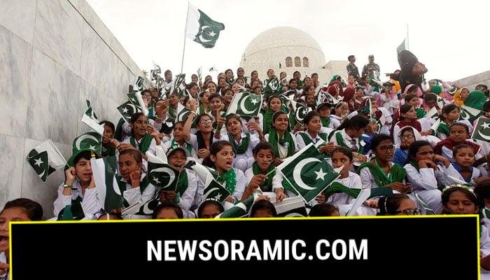 School children wave the national flag and sing patriotic songs at a ceremony to celebrate Independence Day at the mausoleum of Muhammad Ali Jinnah in Karachi. — Reuters