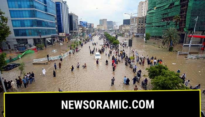 People wade through a flooded road after the monsoon rain in Karachi on August 19, 2025. — Reuters