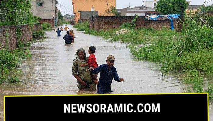 Residents wade through a flooded street, following monsoon rains and rising water levels in Punjabs Sialkot on August 27, 2025. — Reuters