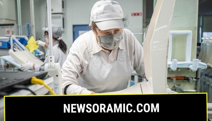 A worker at an assembly line of the Washlet Techno factory of Japanese toilet manufacturer TOTO. — AFP
