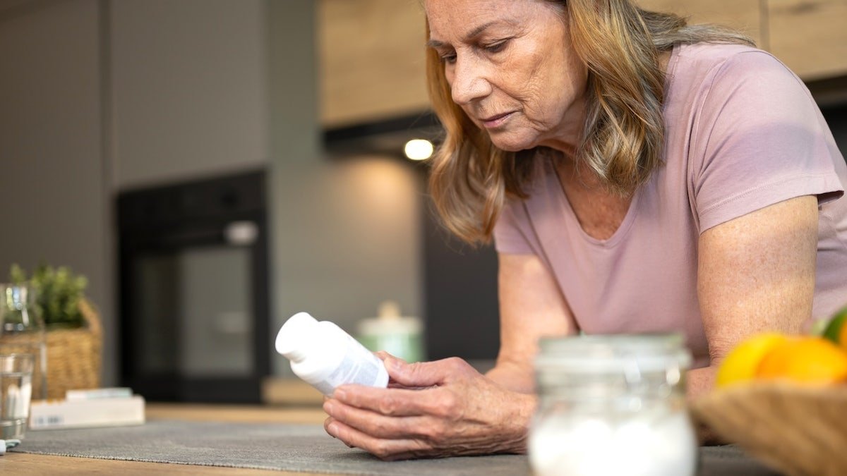 Woman looking at vitamin D bottle