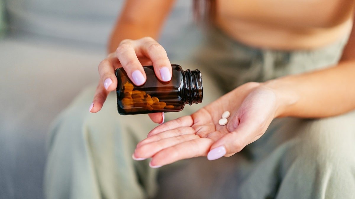 Woman pouring pills into hand