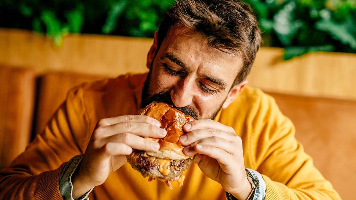 A man eating a cheeseburger.