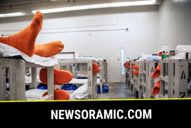 A detainee lays on a bunk in a pod
