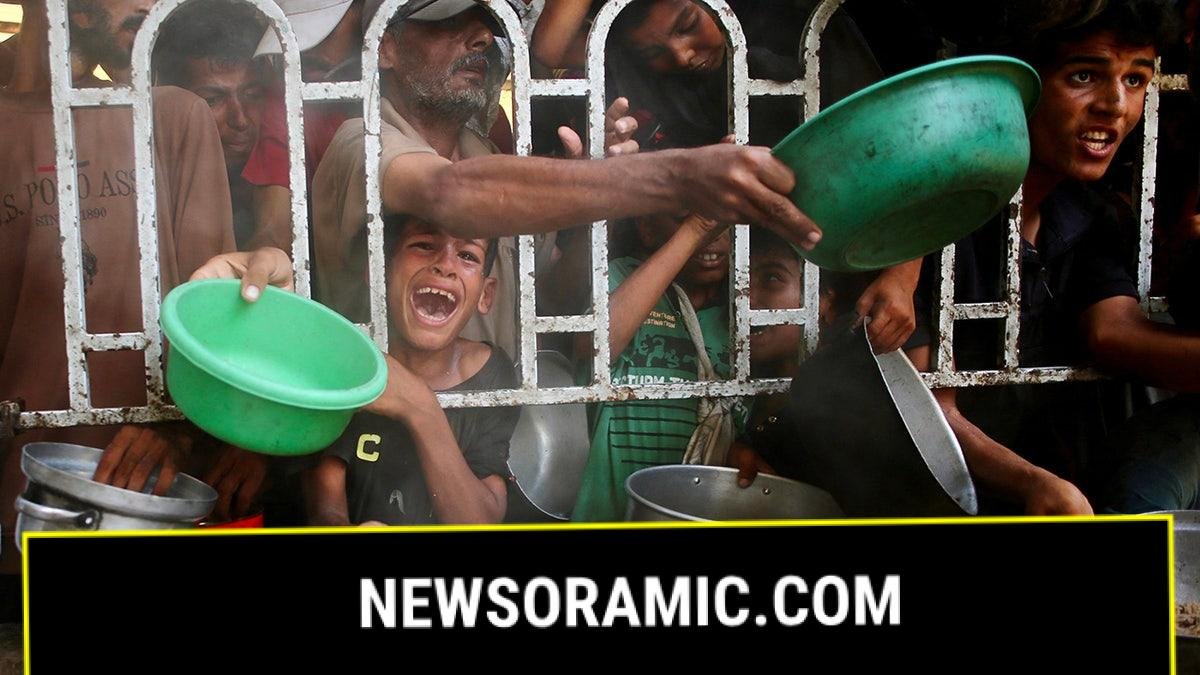Gazans with arms outstretched holding bowls, trying to get food
