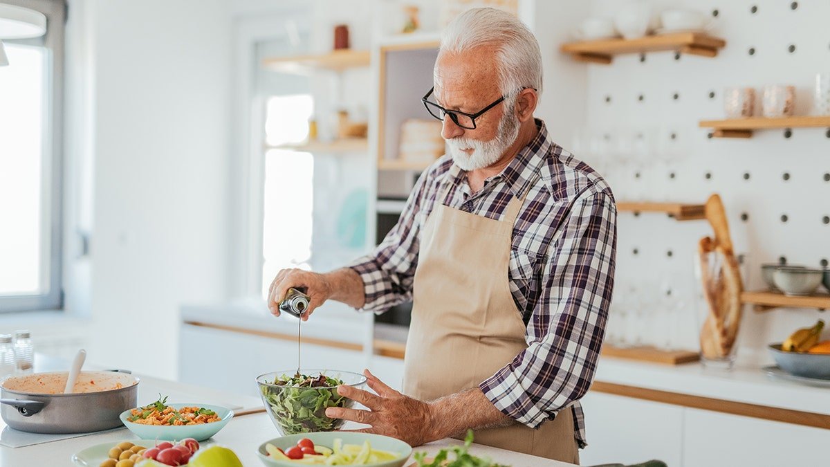 Man with gray hair at home cooking at home