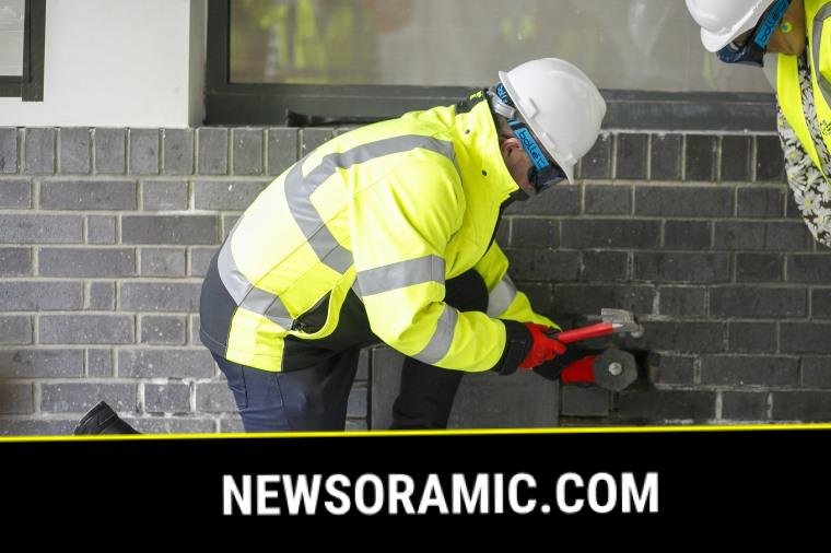 Jason Dawson from the Children's Cancer Centre chiseling the bricks around the time capsule.