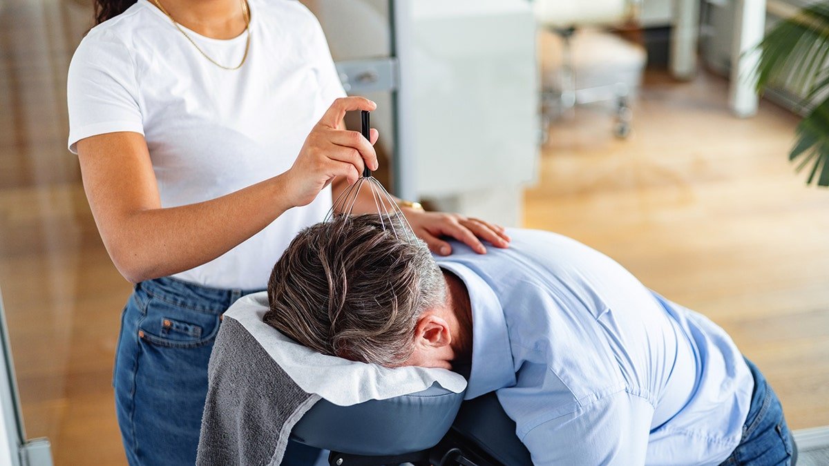 Man receives scalp massage and back scratch