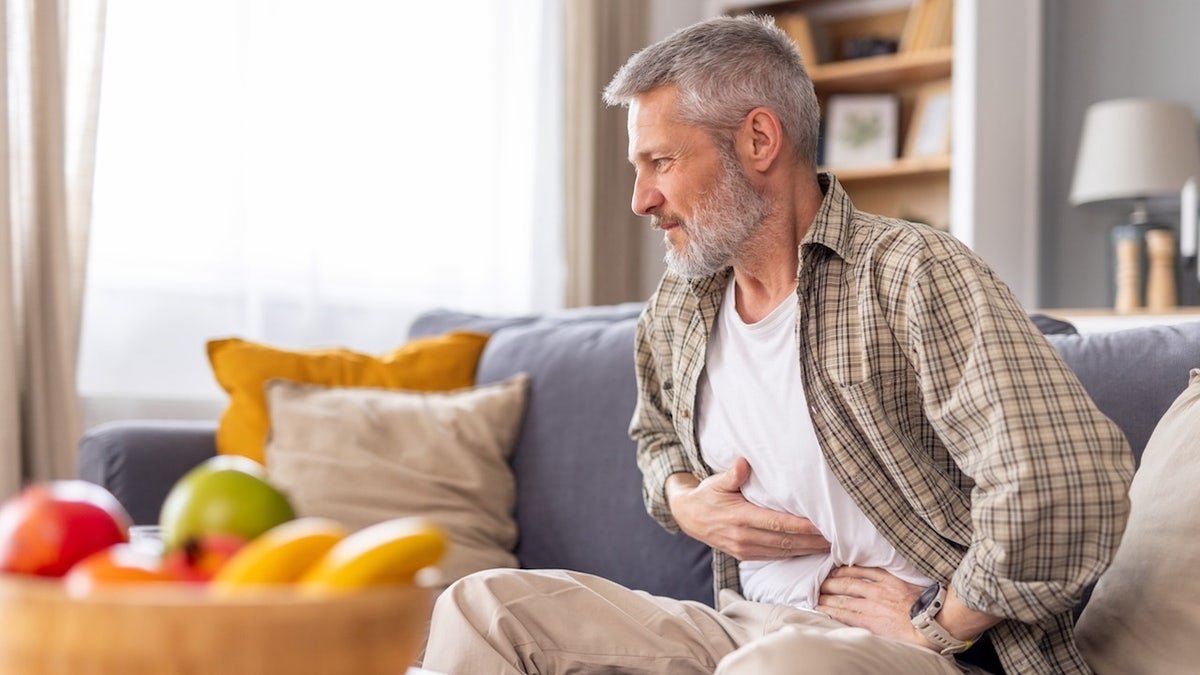 Man with stomach pain in house