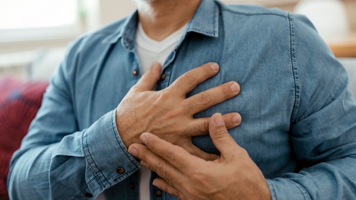 Man holding chest, heart pain