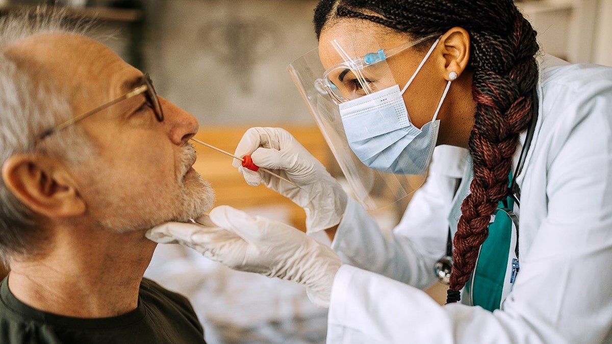 Doctor tests man with nasal swab