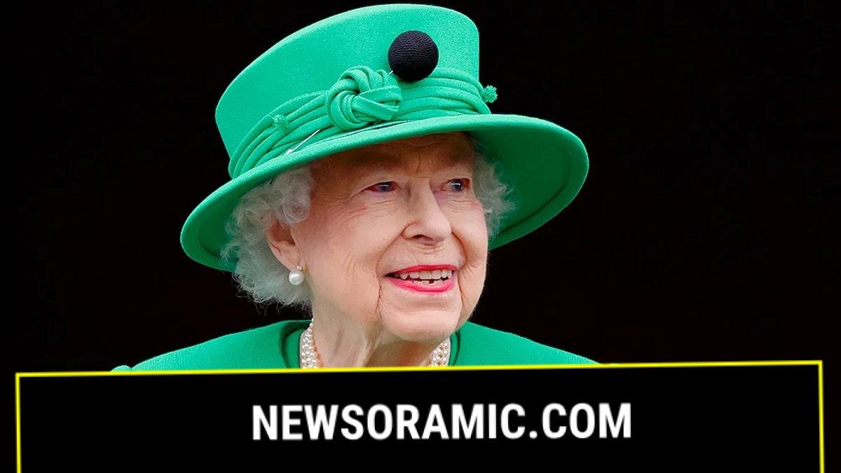 A close-up of Queen Elizabeth wearing a green suit with a matching hat.