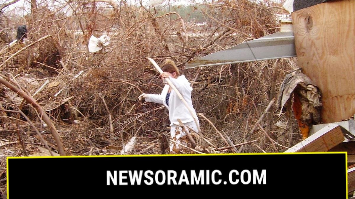 Woman walks through storm debris after Hurricane Katrina in Buras, LA.