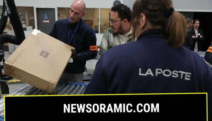 French Customs officers control postal parcels in the Customs area of the postal customs clearance office located in the sorting centre of La Poste, near Orly airport, South of Paris on March 20, 2025. — AFP
