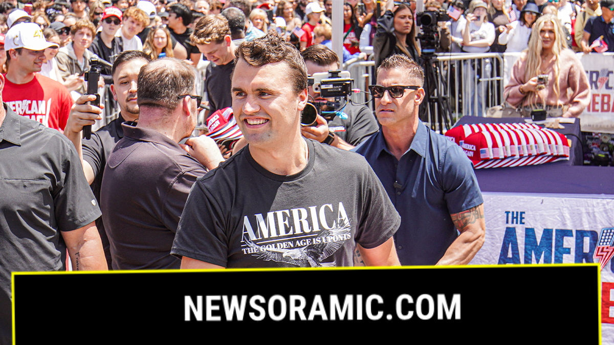 Charlie Kirk smiling while throwing MAGA hats