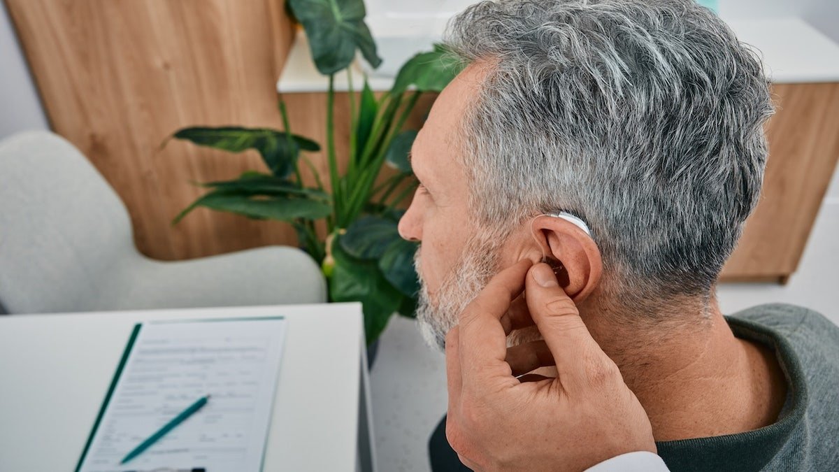 Man getting fitted with hearing aid