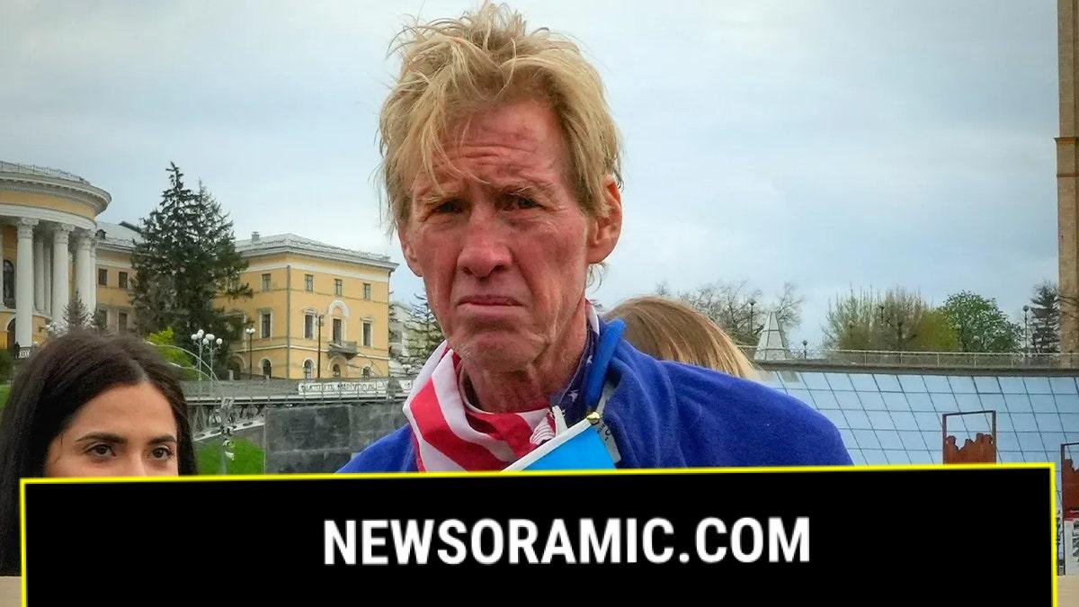 Ryan Wesley Routh looking serious while holding Ukrainian flag