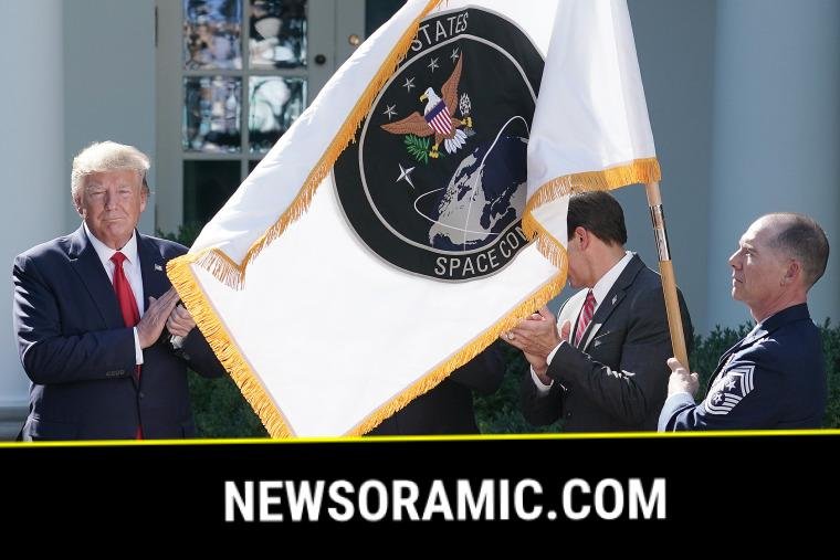 President Donald Trump applauds as the flag for the new the U.S. Space Command is revealed