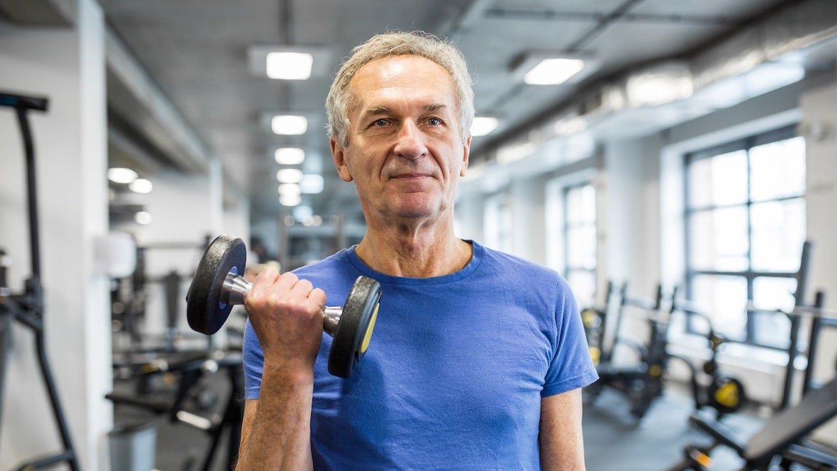 Older man lifting weights in gym