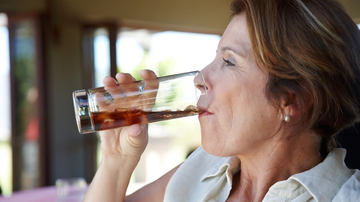 Older woman drinking soda