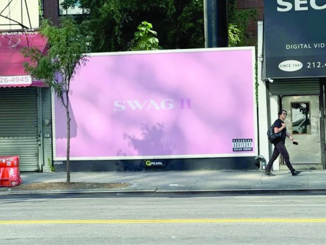people walk by a billboard to promote justin bieber s new album swag ii photo instagram lilbieber