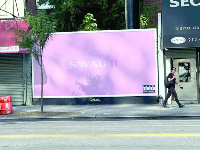 people walk by a billboard to promote justin bieber s new album swag ii photo instagram lilbieber