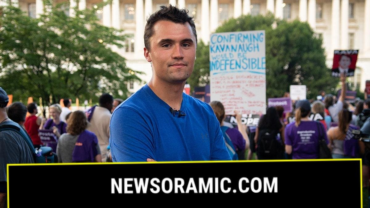 Charlie Kirk in a t-shirt with arms folded